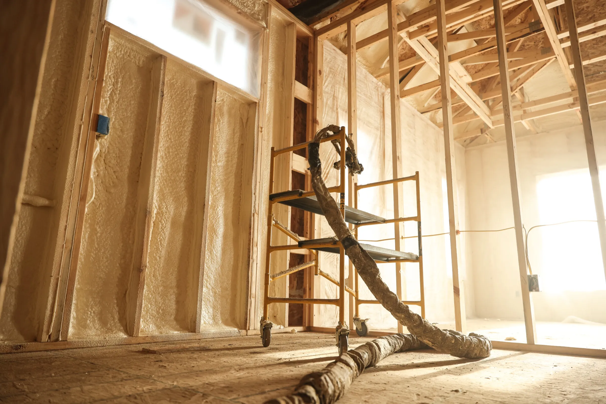 Professional installer applying spray foam insulation in a Mesa-area building